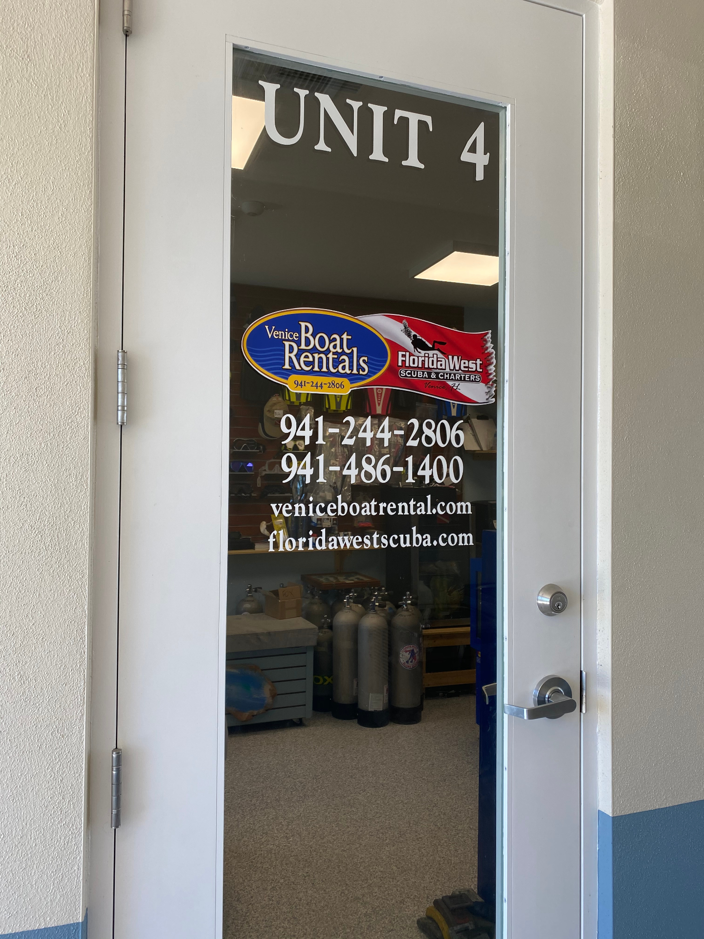 Unit 4 storefront door with Venice Boat Rentals decal